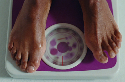 a person standing on a scale with their feet on a bowl