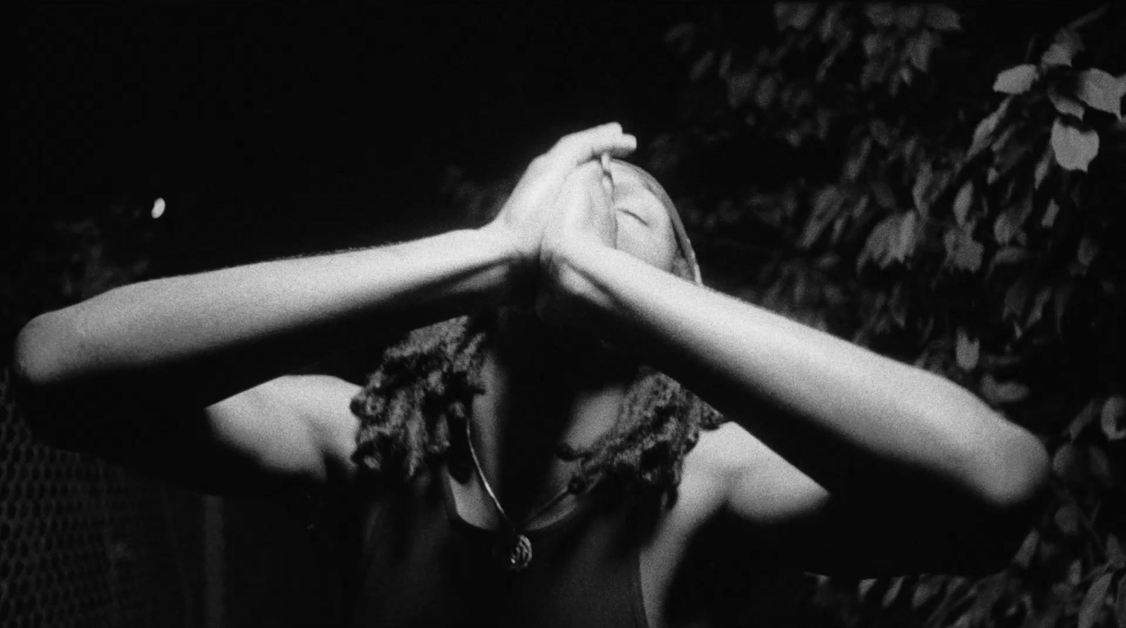 a black and white photo of a woman covering her eyes