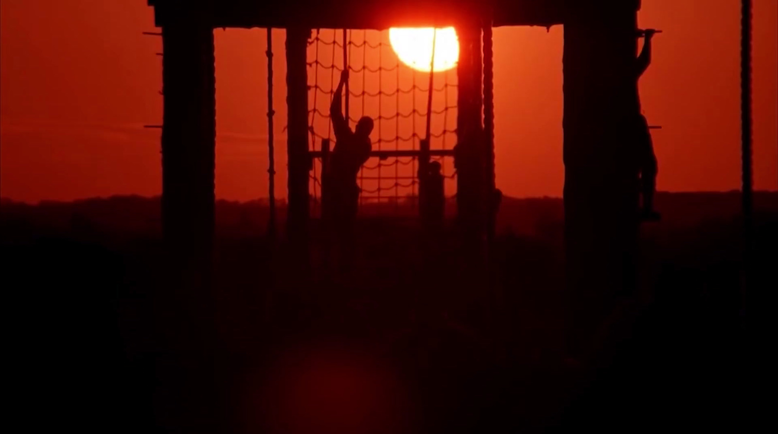 the sun is setting behind a soccer goal