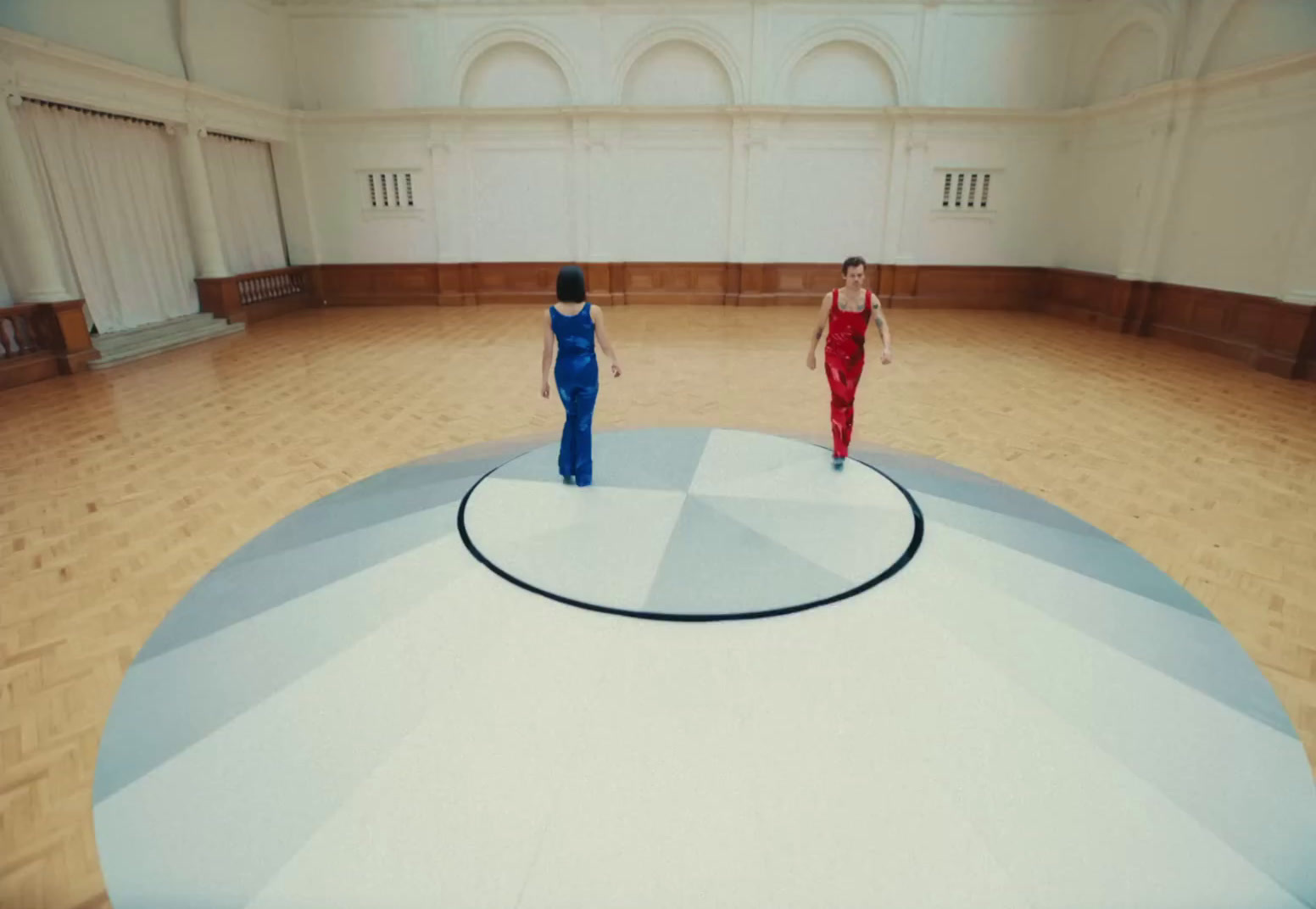 a couple of women standing on top of a wooden floor