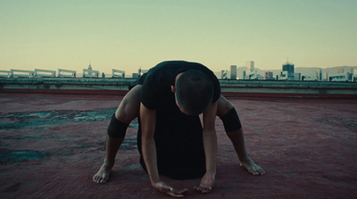 a man in black shirt doing a handstand on a roof