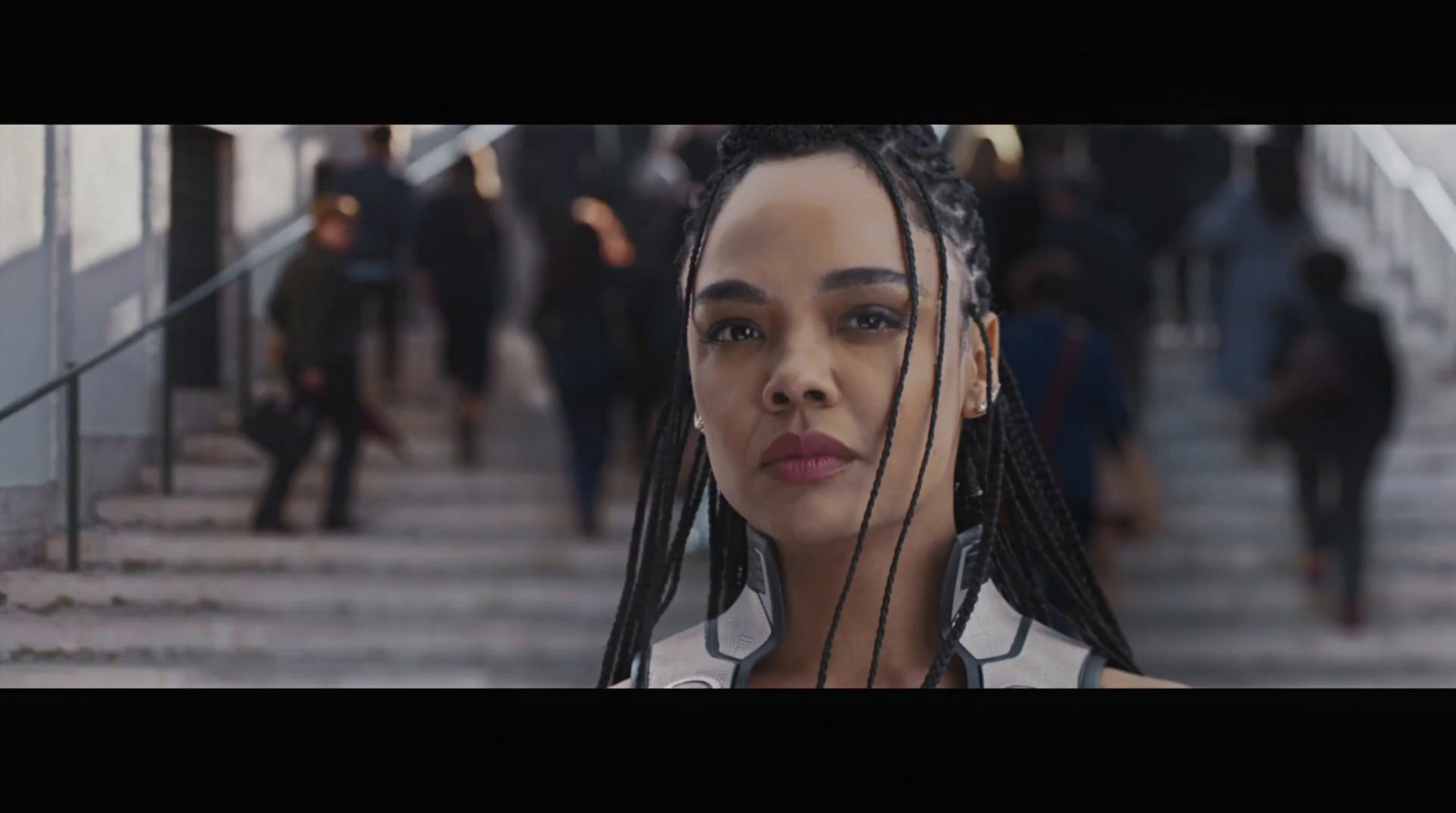 a woman with dreadlocks standing in front of stairs