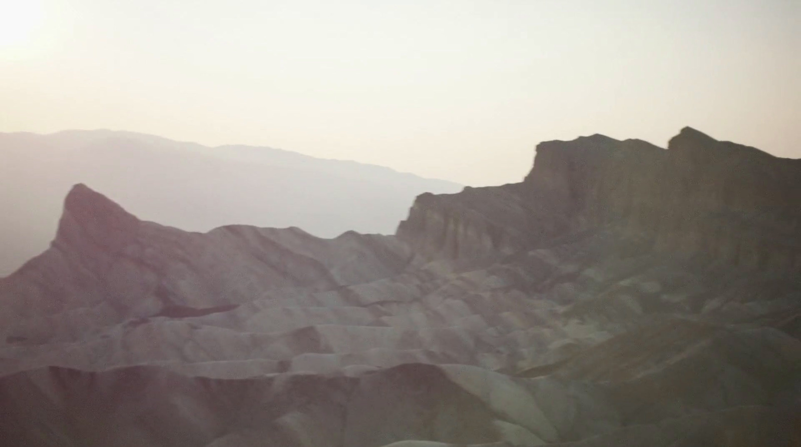 a plane flying over a mountain range with mountains in the background