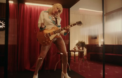 a woman is playing a guitar in a room