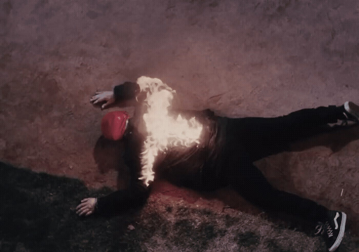 a man laying on the ground with a fireball in his hand