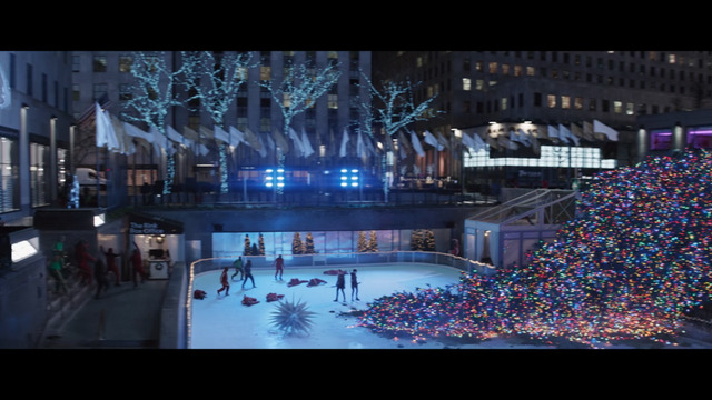 people skating on an ice rink in a city at night