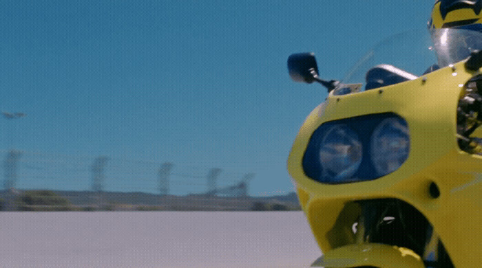 a close up of a yellow motorcycle on a road