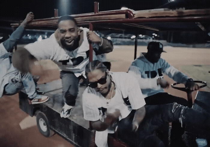 a group of men riding on the back of a truck