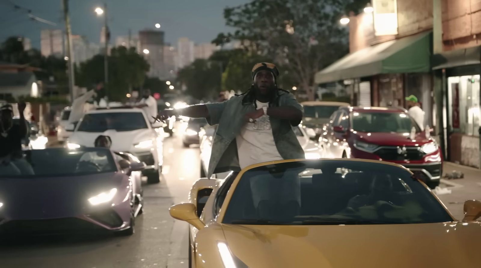 a man standing in front of a yellow sports car