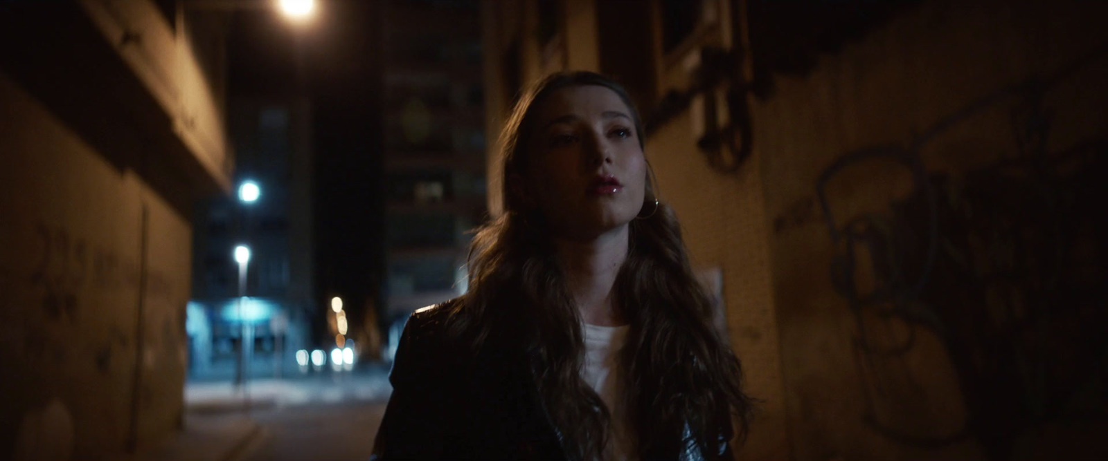 a woman standing on a street at night