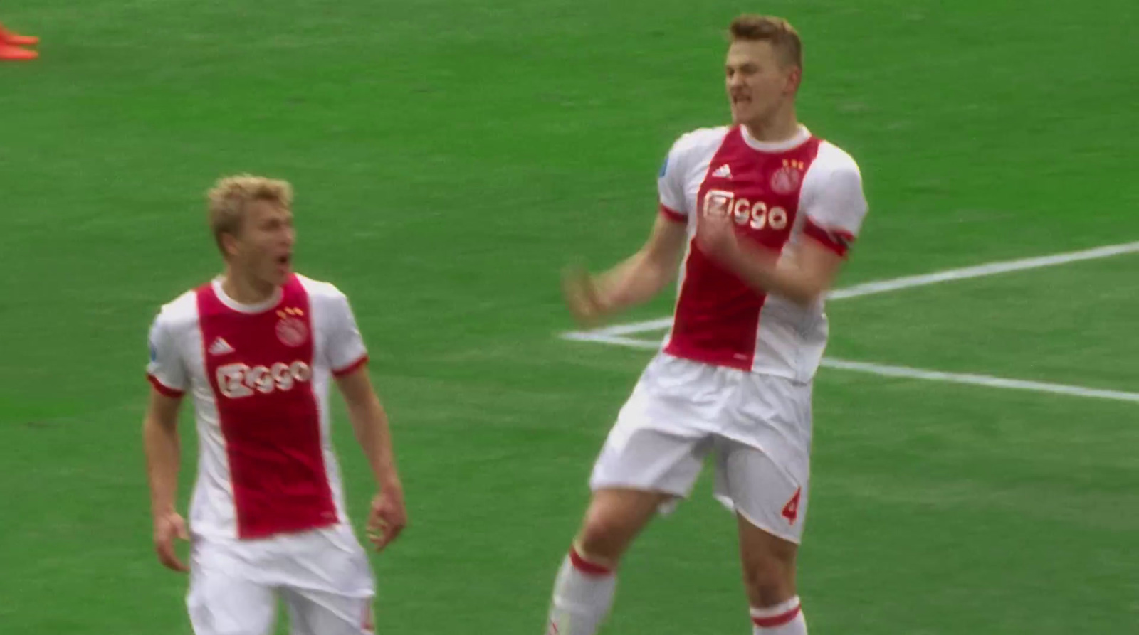 a couple of men standing on top of a soccer field