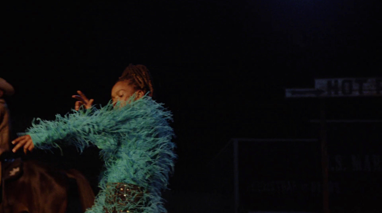 a woman in a blue feathered dress on a horse