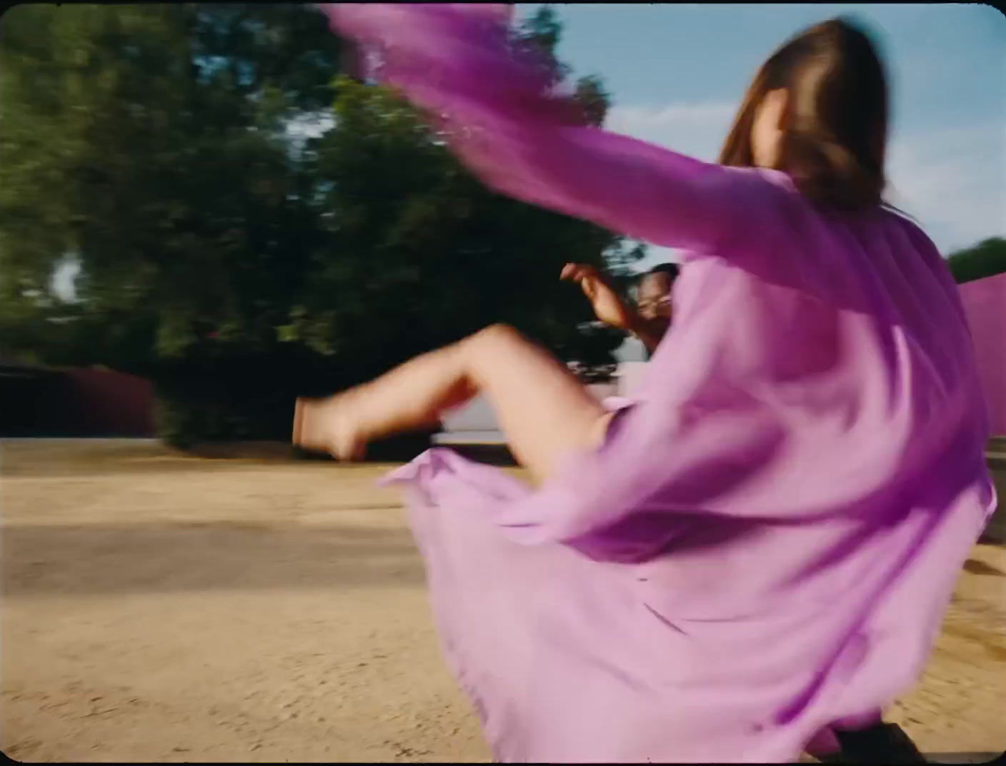 a woman in a purple dress is flying a kite