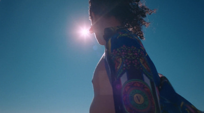 a man with a towel around his neck on a beach