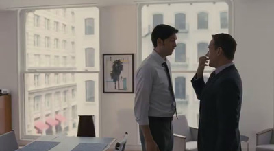 two men standing in an office talking to each other