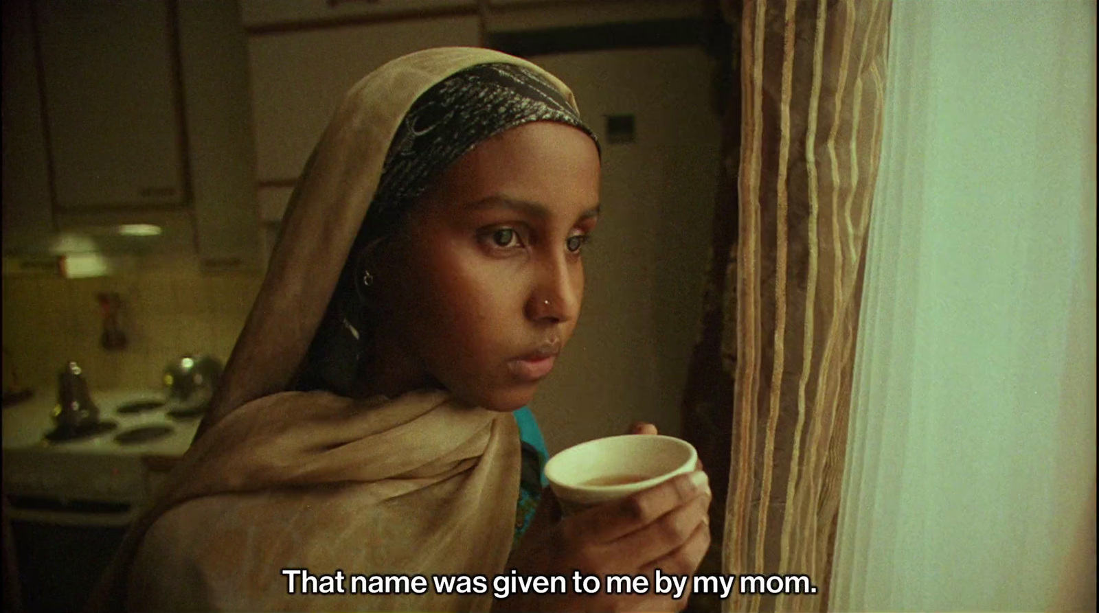 a woman in a headscarf holding a cup