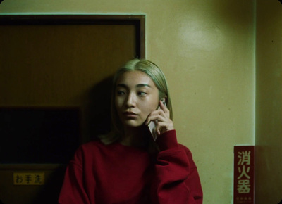 a woman in a red sweater talking on a cell phone