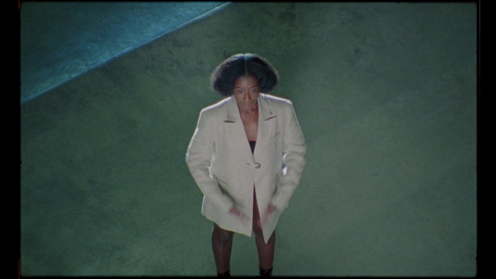 a woman in a white coat standing on a runway