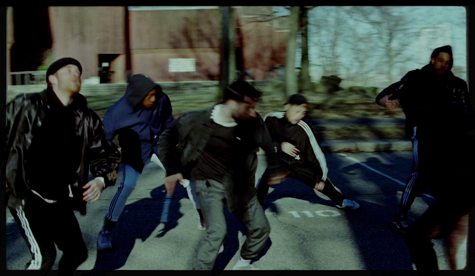 a group of young men walking across a parking lot