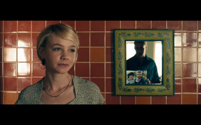 a woman standing in front of a picture of a man