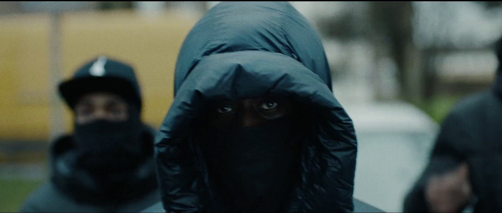 a group of people wearing black hoods and covering their faces