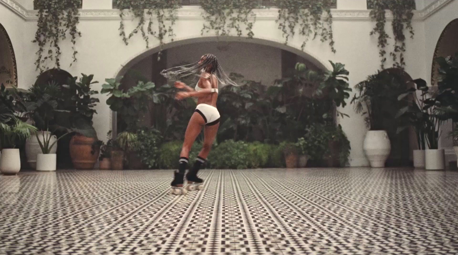 a woman in a short skirt is dancing on a tiled floor