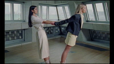 a couple of women standing on top of a hard wood floor