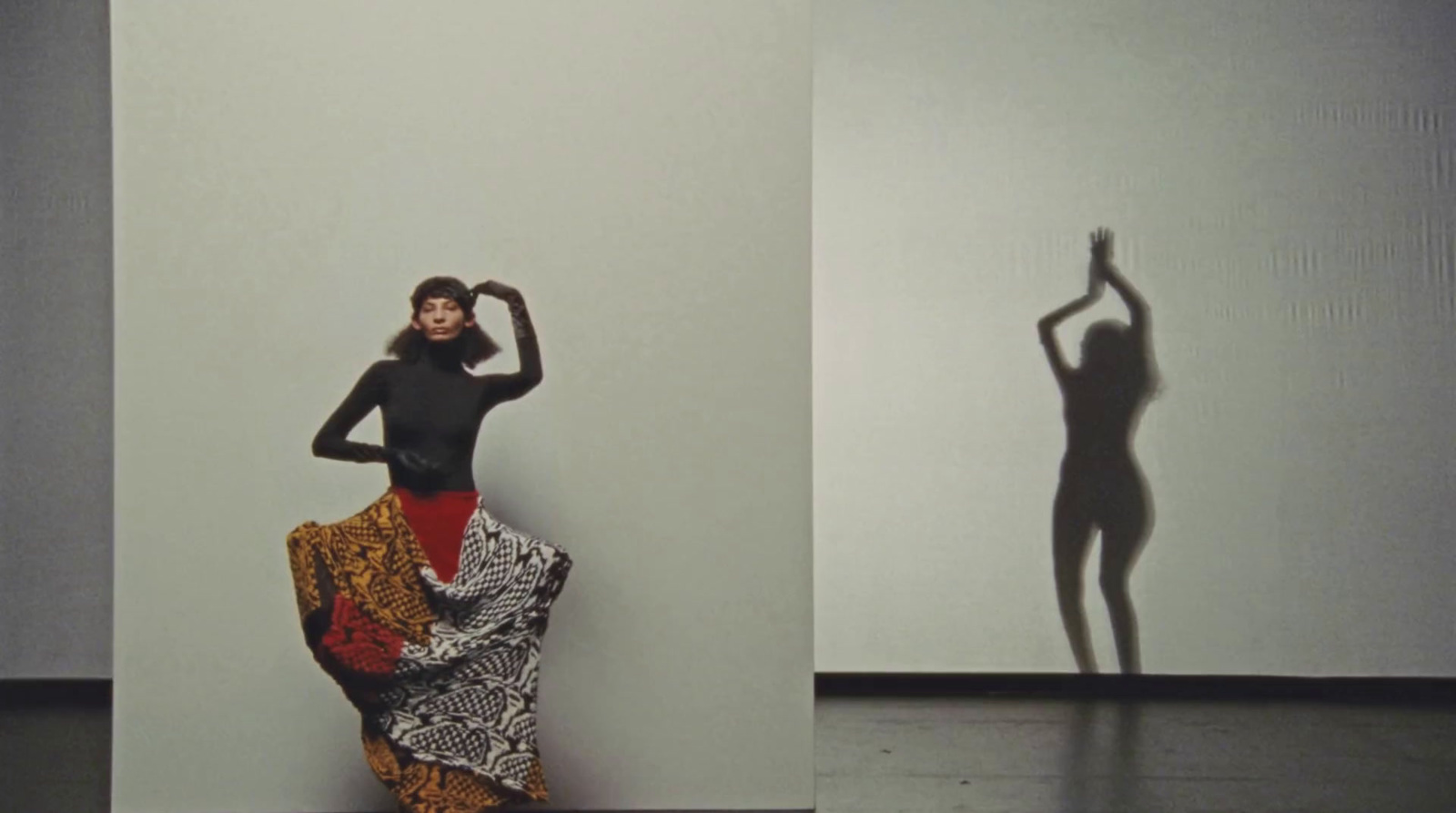 a woman standing in front of a white wall