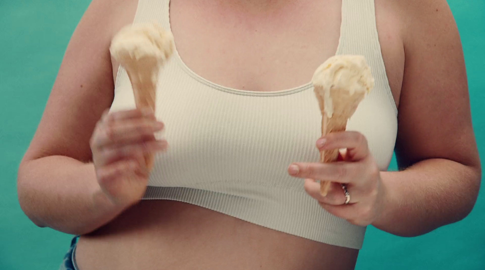 a woman in a white tank top holding two wooden utensils