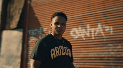 a man standing in front of a wall with graffiti on it