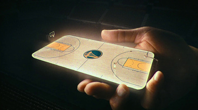 a person holding a cell phone with a basketball court on it