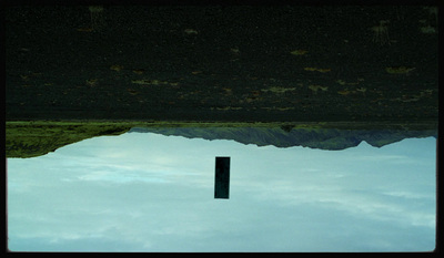 a reflection of a mountain in a pool of water