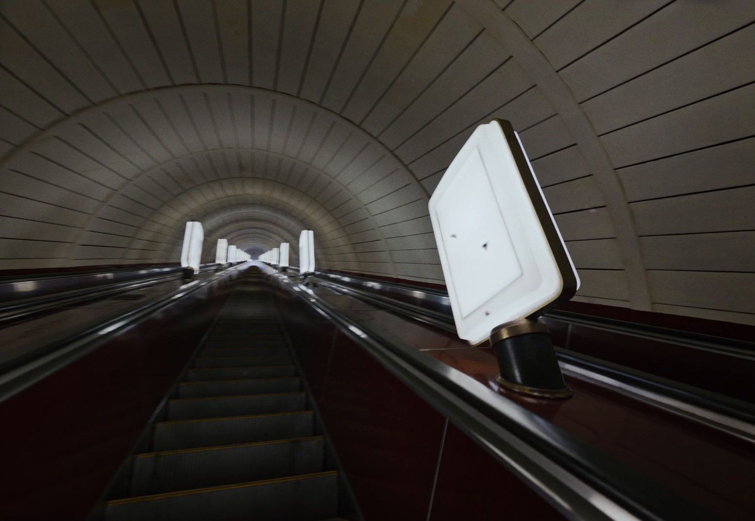 an escalator in a tunnel with a sign on it