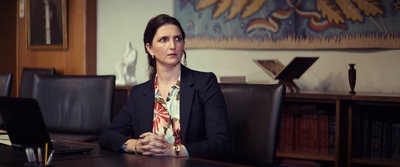 a woman sitting in front of a laptop computer