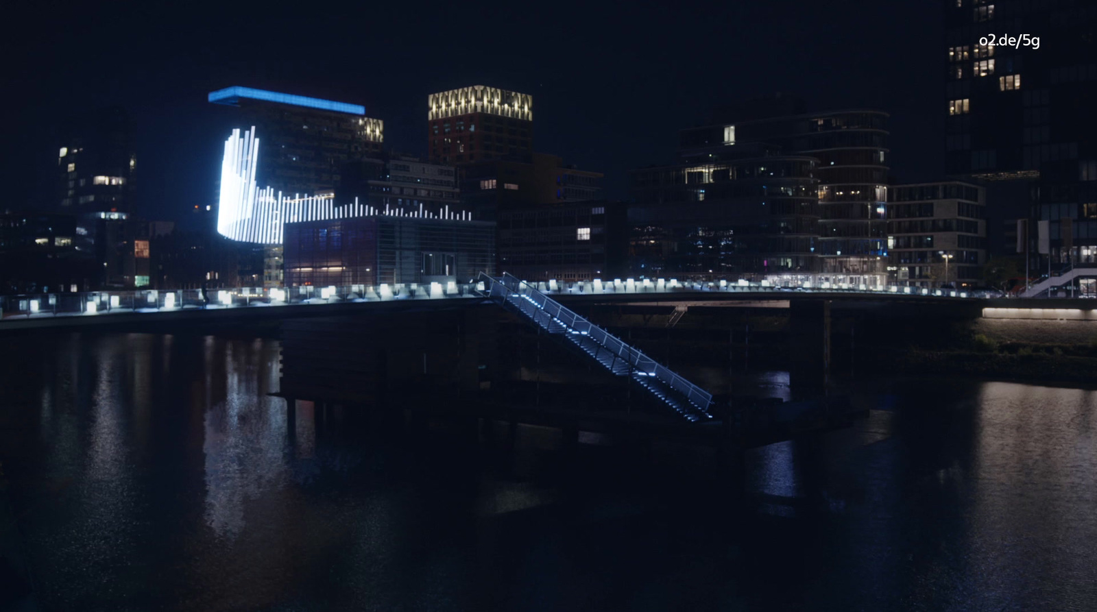 a city at night with a bridge over a river