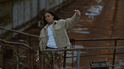 a woman standing on a bridge pointing at something