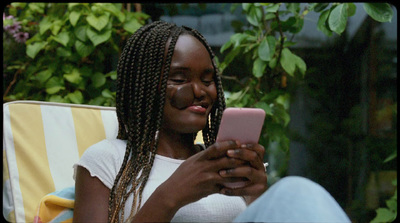 a woman sitting in a chair looking at her cell phone