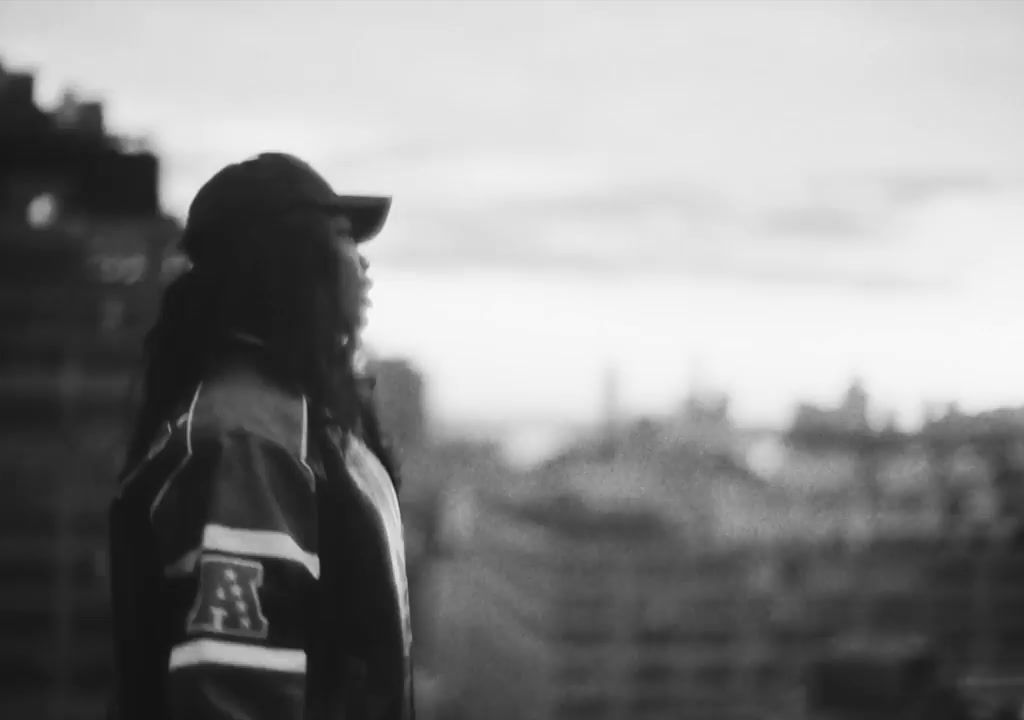 a black and white photo of a person wearing a baseball cap