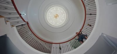 a spiral staircase with people walking up and down it