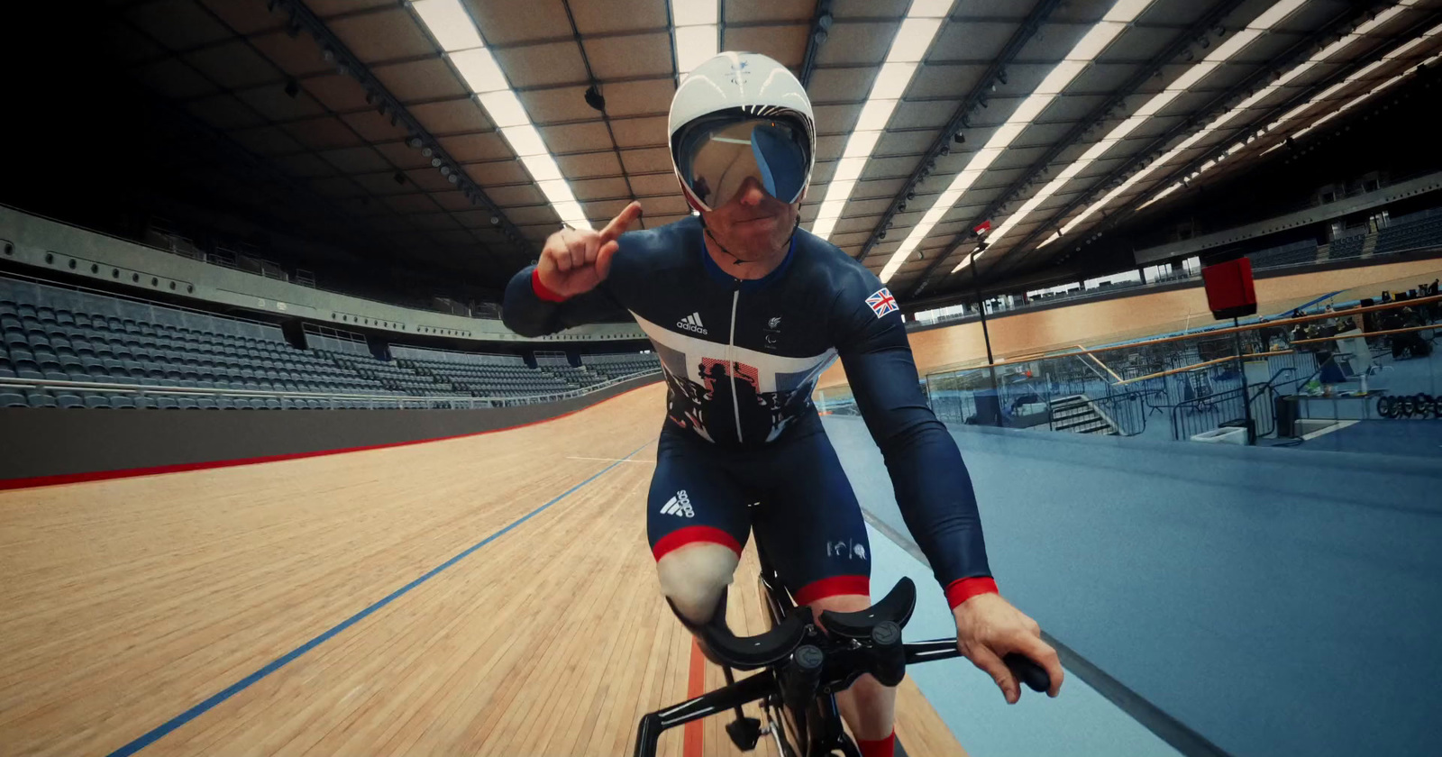 a man riding a bike on top of a wooden floor