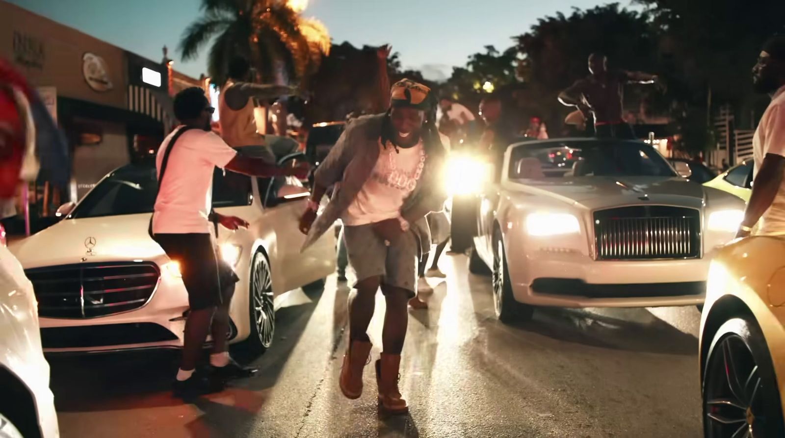 a group of people standing around a bunch of cars