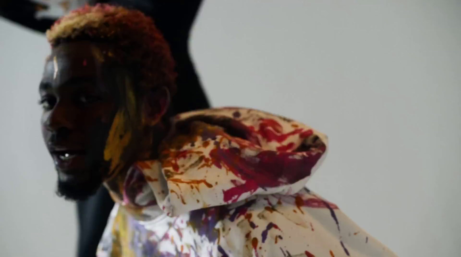 a man in a white jacket with paint all over his face