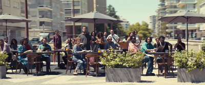 a group of people sitting at tables with umbrellas