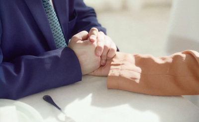 a man and a woman holding hands at a table