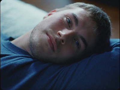 a man laying on top of a bed next to a pillow