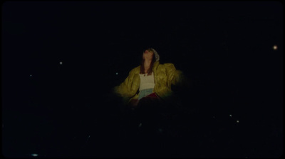 a person standing in the dark with a yellow jacket