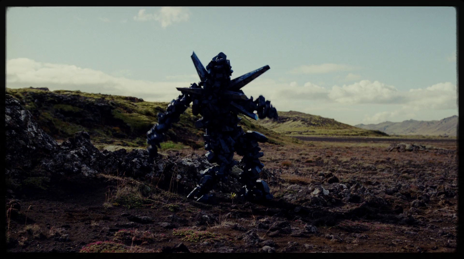 a large robot standing on top of a dirt field