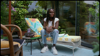 a woman sitting on a chair in a backyard