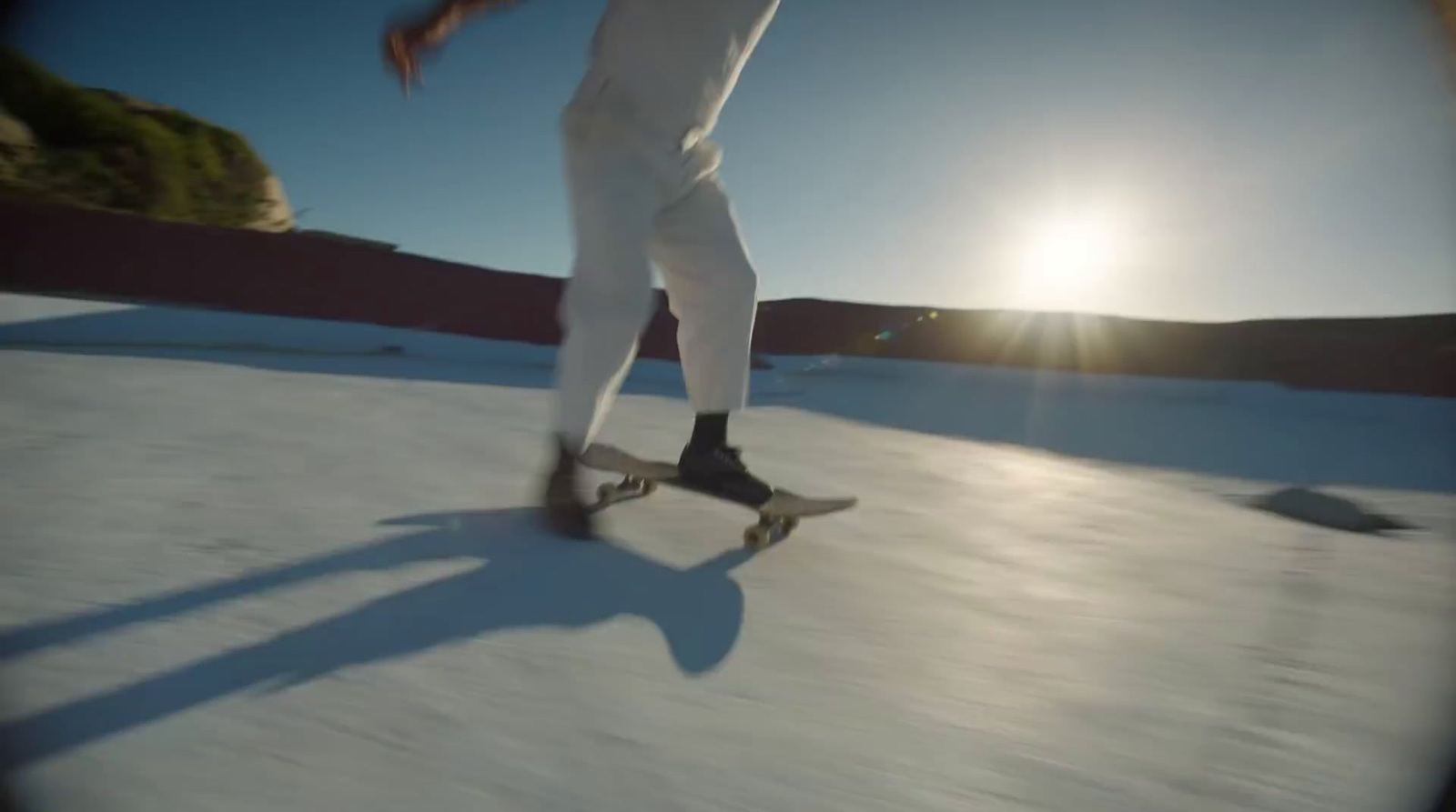 a man riding a skateboard down a snow covered slope