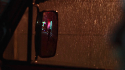 a rear view mirror of a car with rain falling on it